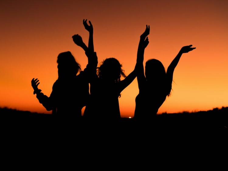 Tre kvinnor i solnedgång